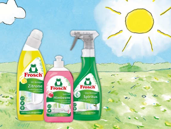 Comic Frosch mit Liegestuhl auf der Wiese. Daneben steht das Frosch Sensitiv-Waschmittel Aloe Vera Nachfüllbeutel